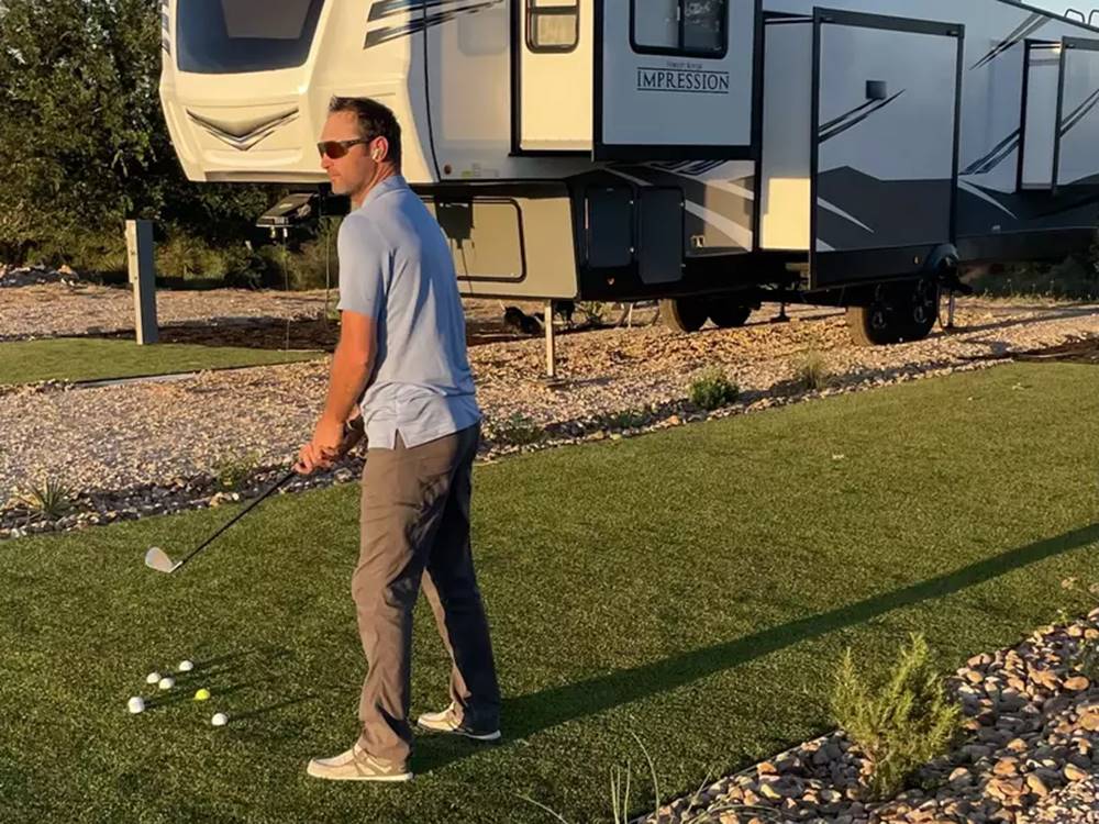 Golfer working on their chipping next to their RV