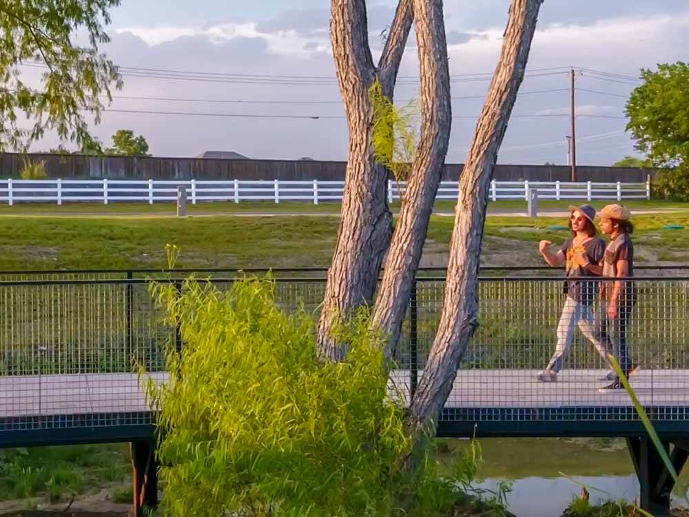 Two men walking over a bridge at BUDA PLACE RV RESORT