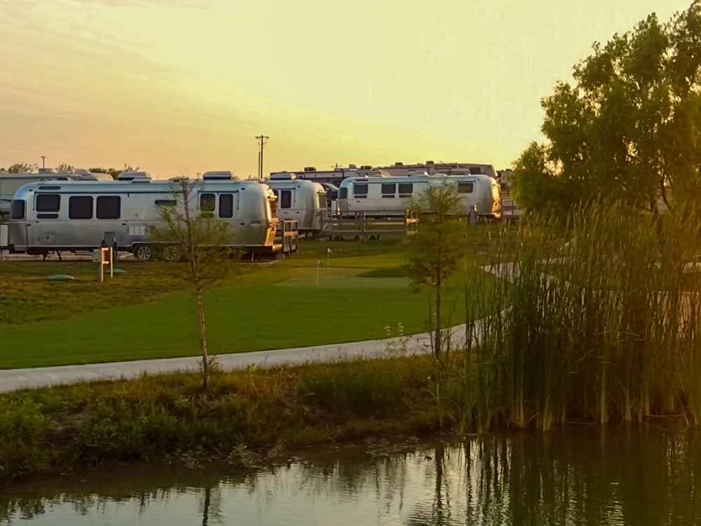 A row of trailers in RV sites at BUDA PLACE RV RESORT