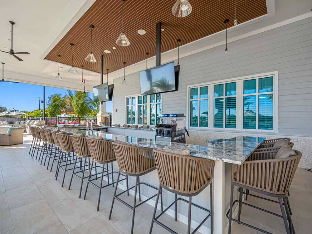 A group of stools around an outdoor bar at THE SURF RV RESORT