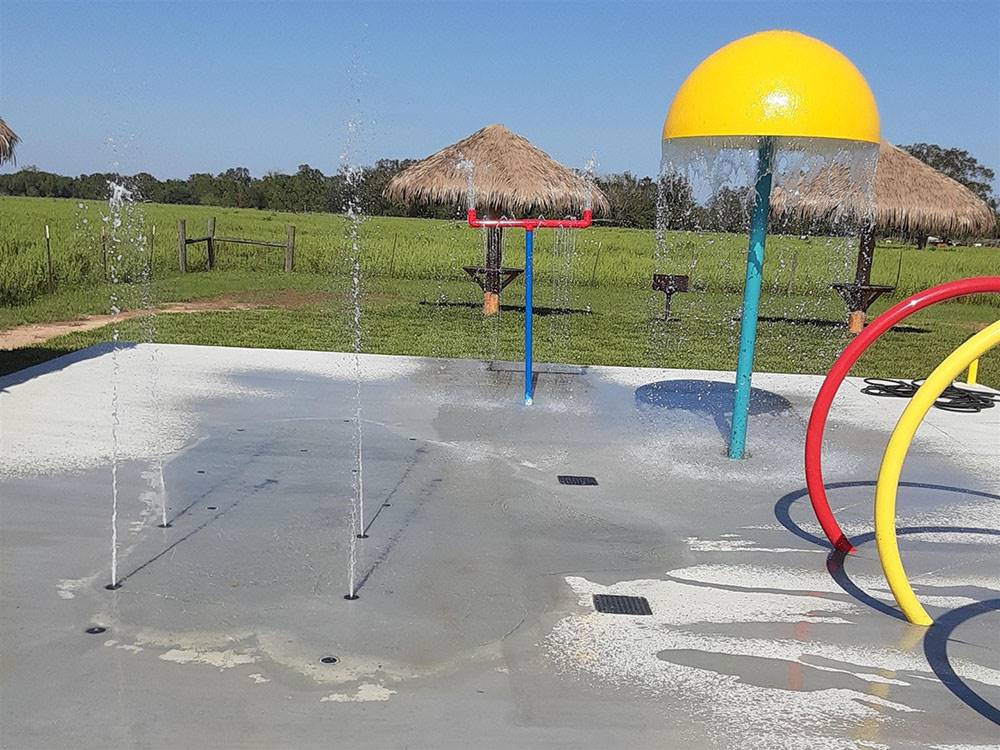 The splash pad with tiki huts at SUGAR VALLEY RV RESORT BY RJOURNEY