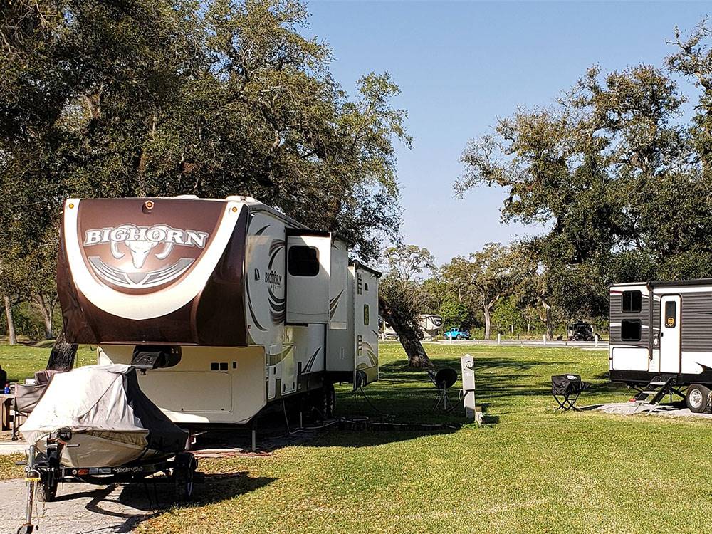 Two fifth wheel trailers in gravel sites at SUGAR VALLEY RV RESORT BY RJOURNEY