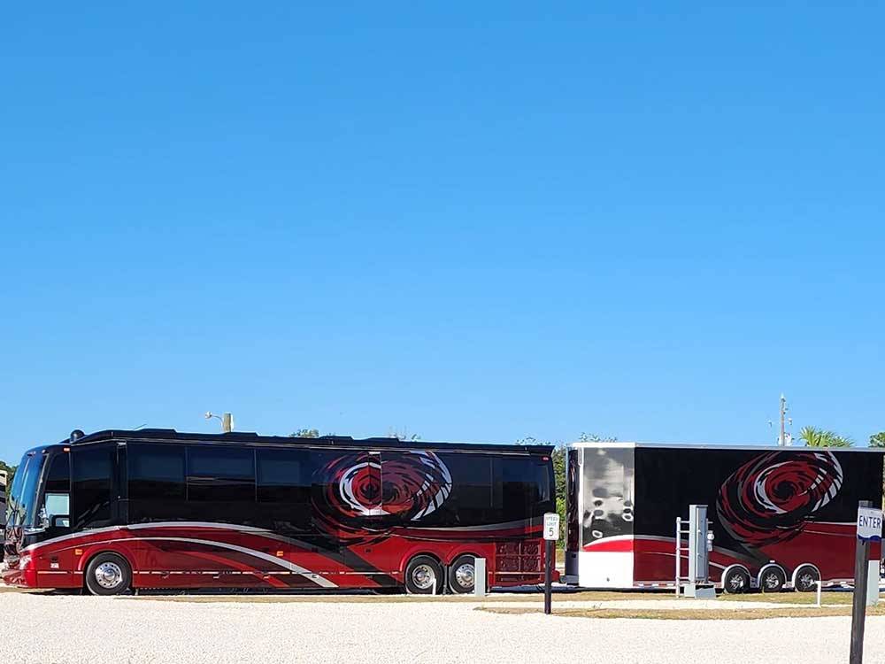 Red and black motorhome with trailer at PORT ST JOE RV RESORT
