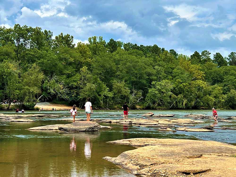 A group of people playing in the river at BROAD RIVER CAMPGROUND