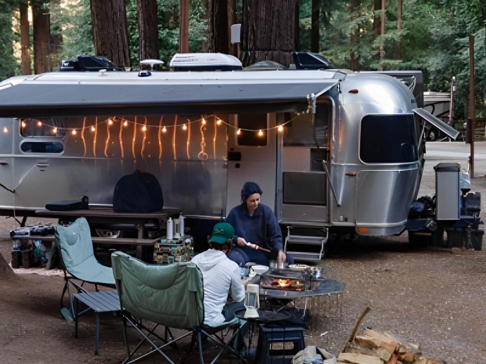 People roasting marshmallows in front of their Airstream trailer