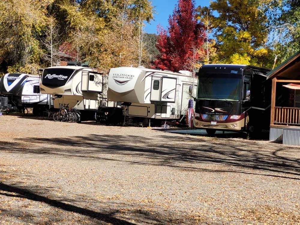 A row of trailers parked in gravel sites at OUTPOST MOTEL CABINS AND RV PARK