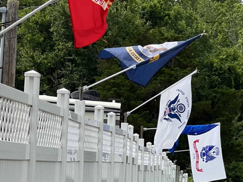 A white fence with flags at BUTTON'S FAMILY CAMPGROUND