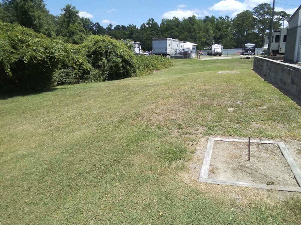 The horseshoe pits in a grassy field at BUTTON'S FAMILY CAMPGROUND