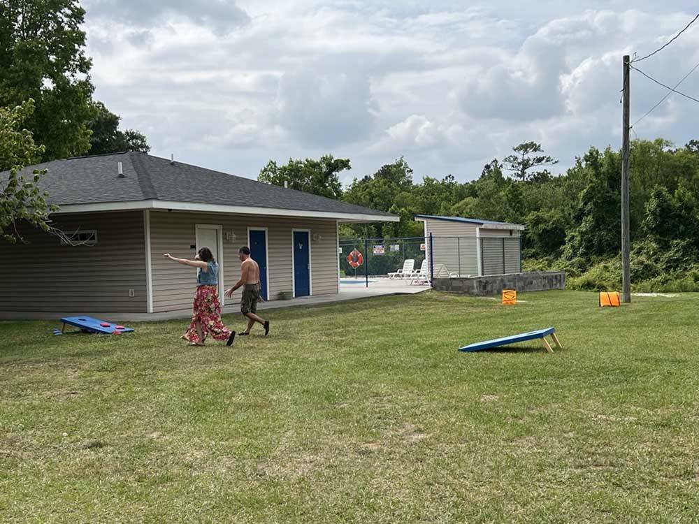 A couple playing corn hole at BUTTON'S FAMILY CAMPGROUND