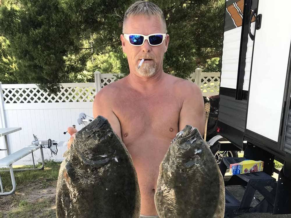 A man holding two flounders at BUTTON'S FAMILY CAMPGROUND