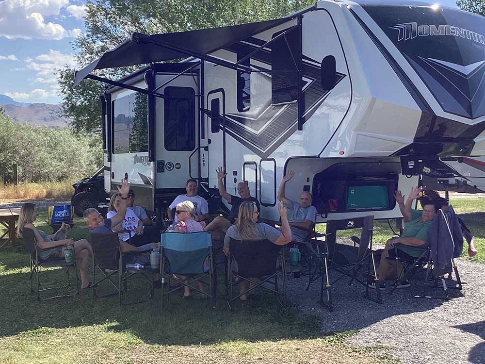 A group of people sitting around a fifth wheel trailer at WHITE KNOB MOTEL & RV PARK