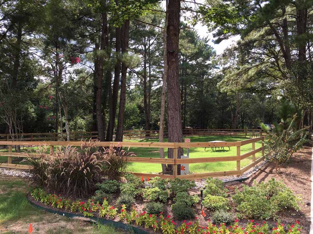Nicely landscaped area with fence at MAJESTIC PINES RV RESORT