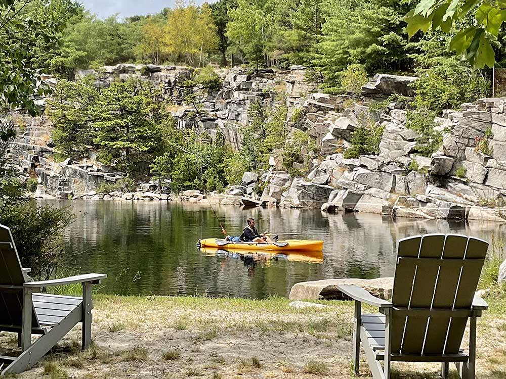 Kayaker on the water with Adirondack chairs overlooking at HTR ACADIA