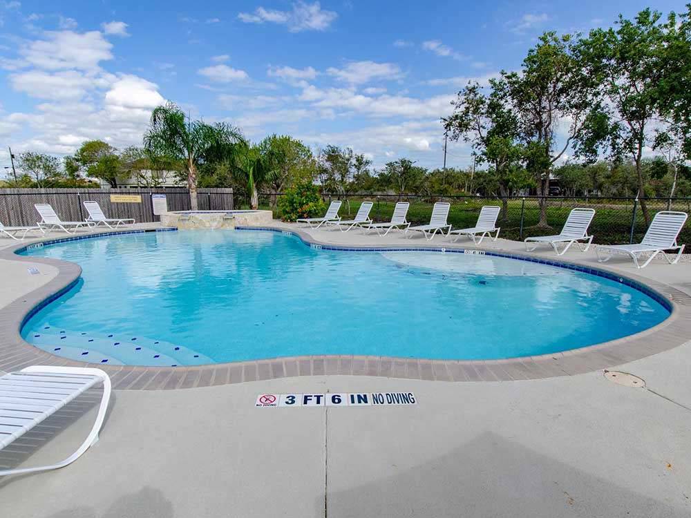 Swimming pool with folding chairs at PORT O'CONNOR RV PARK