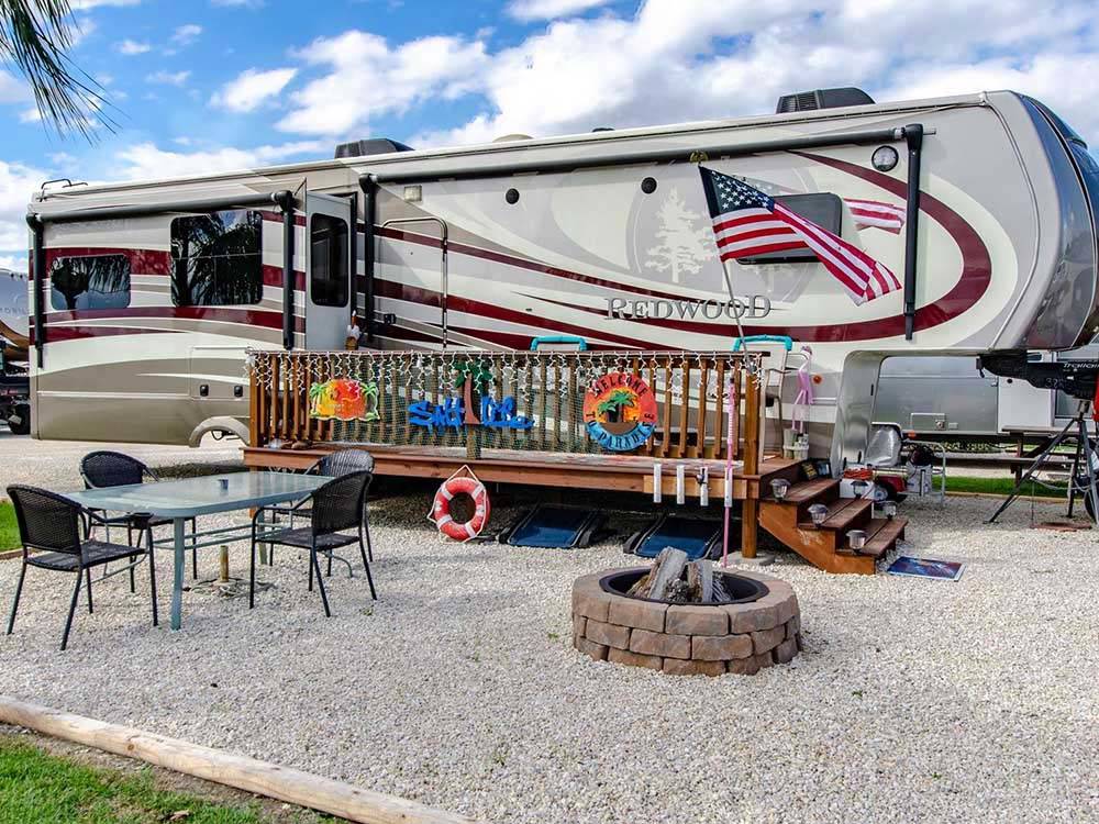 Close-up of RV site with deck and fire pit at PORT O'CONNOR RV PARK