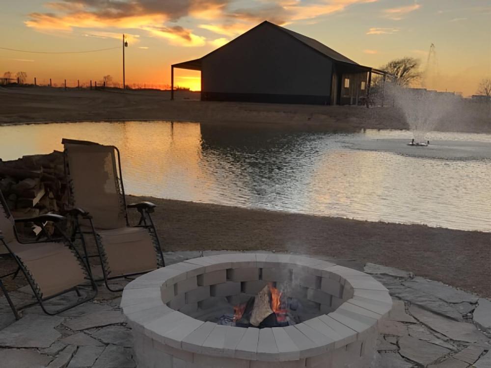 A fire pit with pond in the background