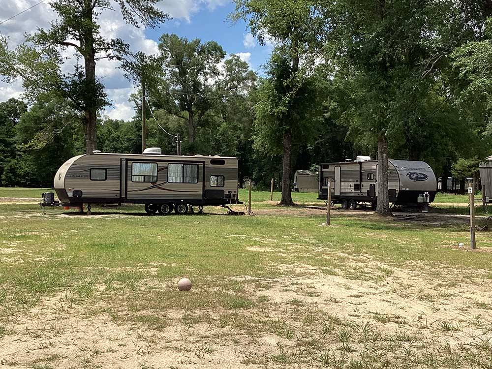 Two travel trailers parked on grassy sites at CHICKASAWHAY RIVER RV PARK