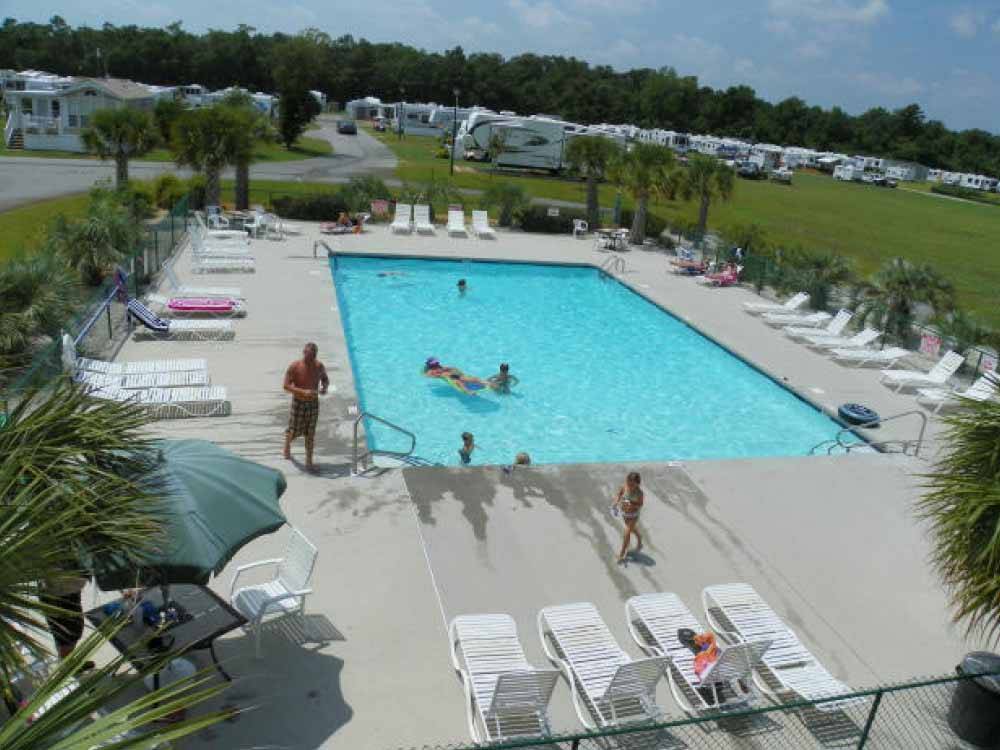 Rectangular swimming pool surrounded by lounge chairs at TOPSAIL SOUND RV PARK