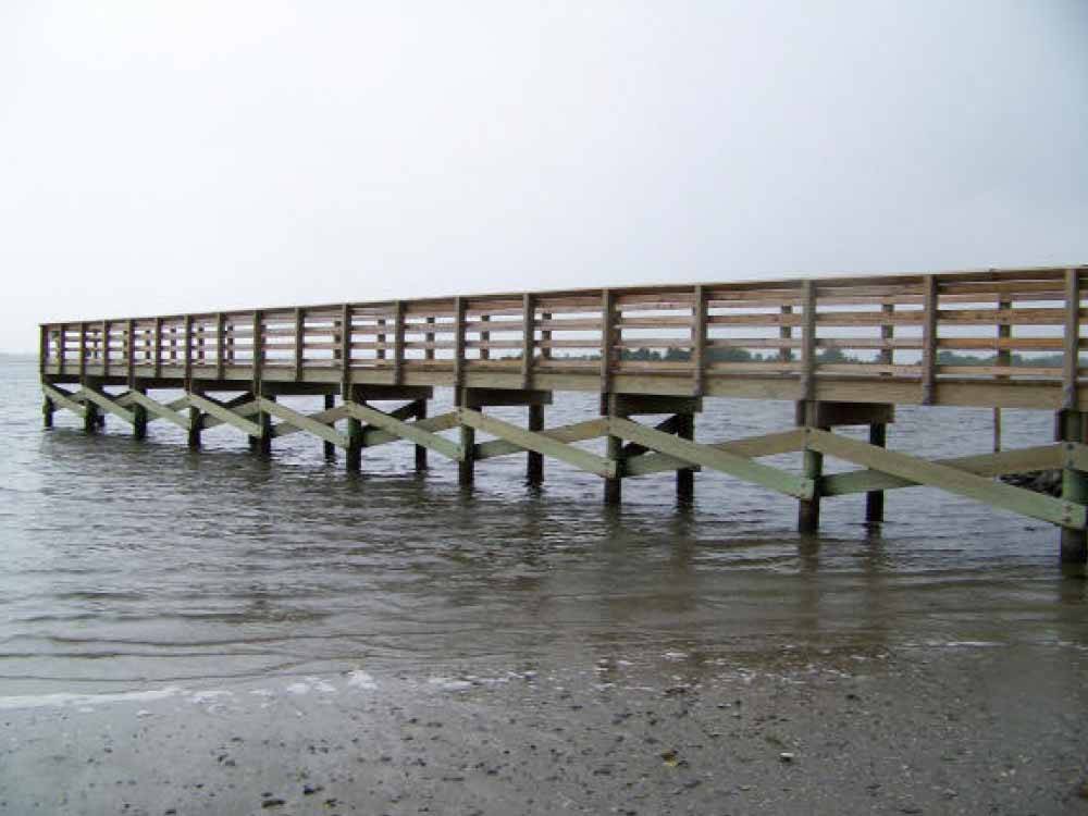 Pier extending out into large body of water at TOPSAIL SOUND RV PARK