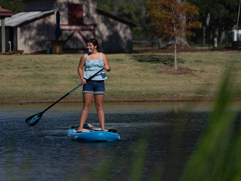 A young woman paddling on the water at GULF SHORES RV RESORT