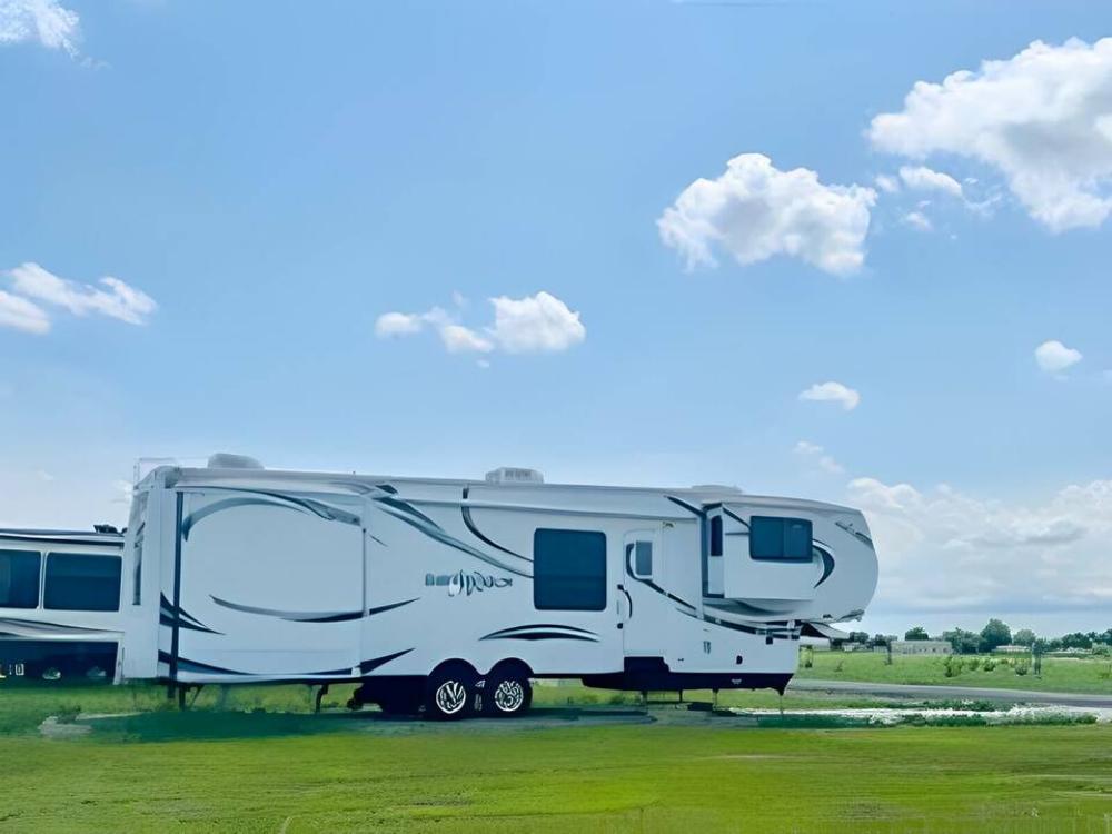 Large fifth wheel in a grassy site at Cherokee Creek RV Park