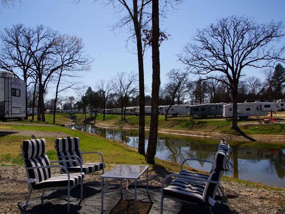 A seating area by the water at BLUE SKY CEDAR CREEK LAKE RV PARK