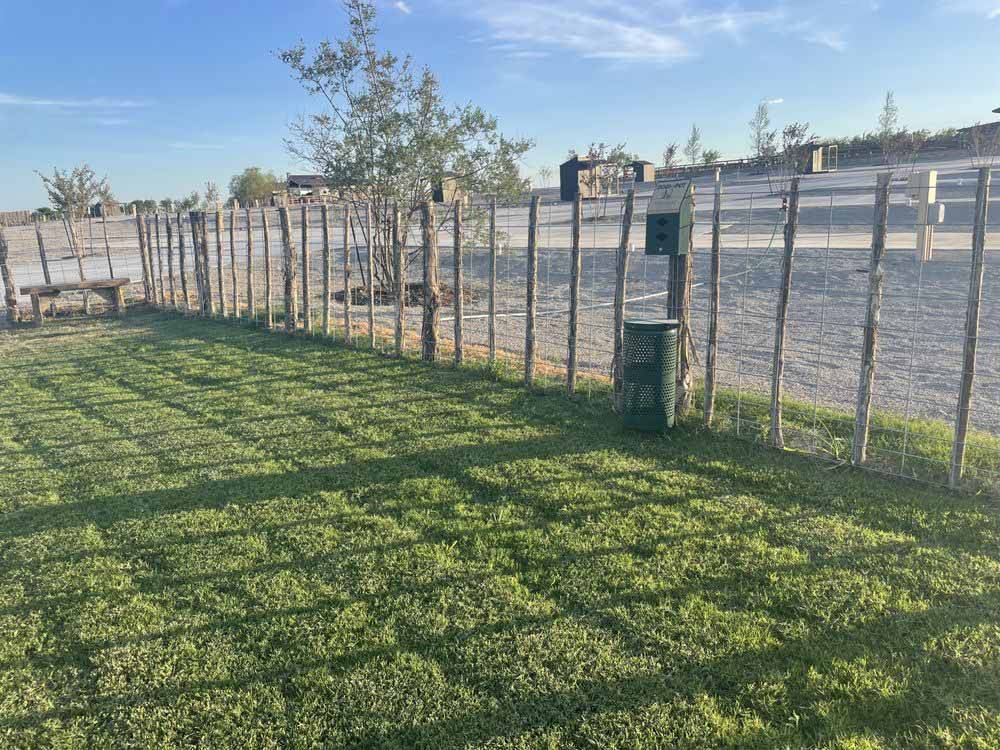 The green fenced in pet area at YELLOW ROSE RV RESORT