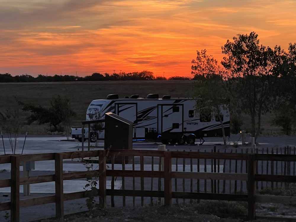 A travel trailer at sunset at YELLOW ROSE RV RESORT