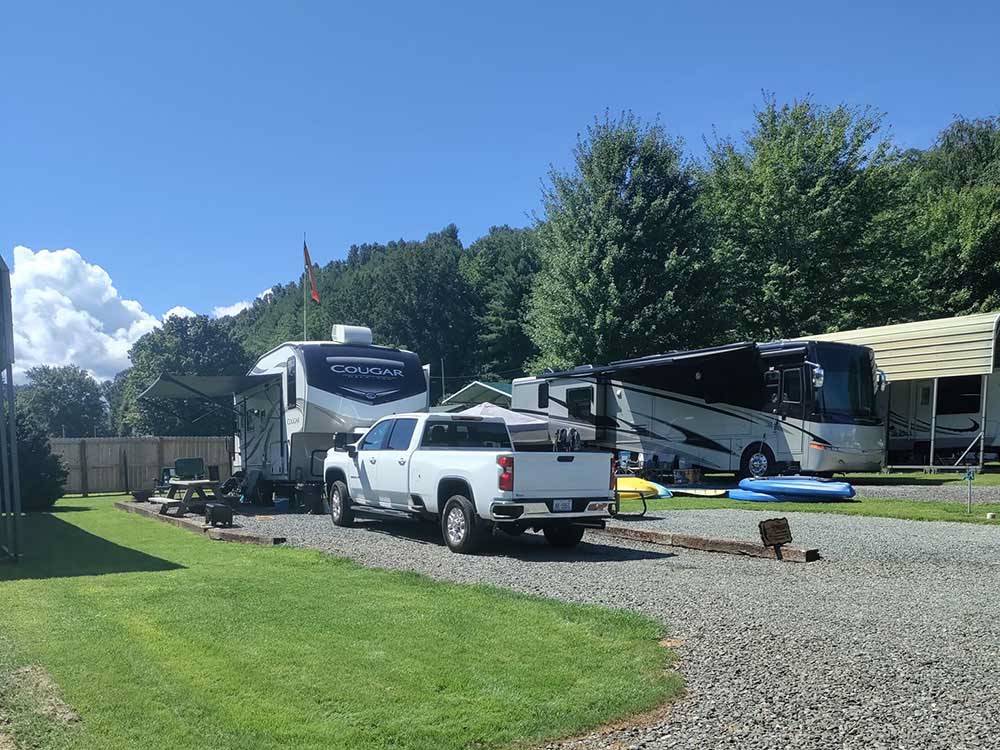 A white truck and Cougar trailer parked in a gravel site at NEW RIVER BRIDGE FAMILY CAMPGROUND