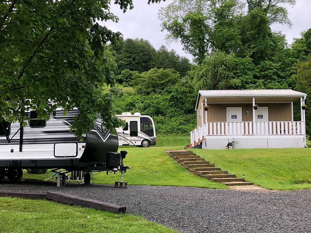 Motorhome and trailer parked by the restroom at NEW RIVER BRIDGE FAMILY CAMPGROUND