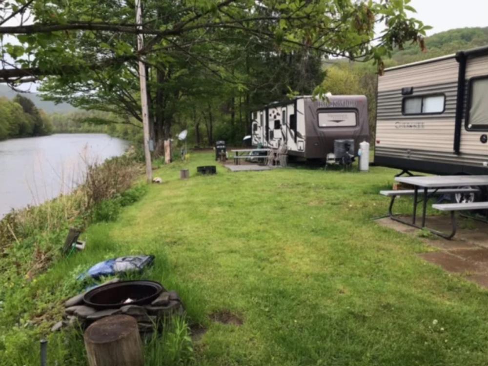Two trailers by the river at Butternut Grove Campsites