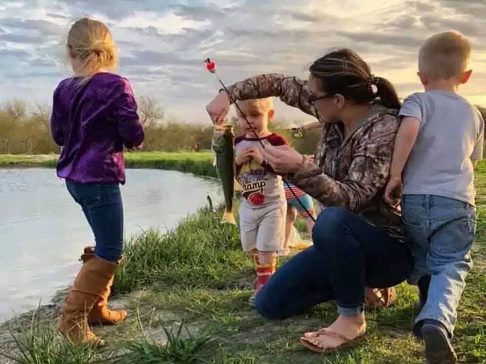A woman prepping children for fishing at SOUTHBOUND RV PARK AND CABINS