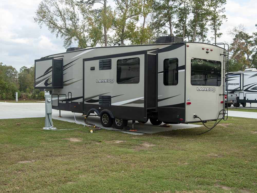 A fifth wheel trailer with its slide outs in a RV site at ROYAL OAKS RV PARK