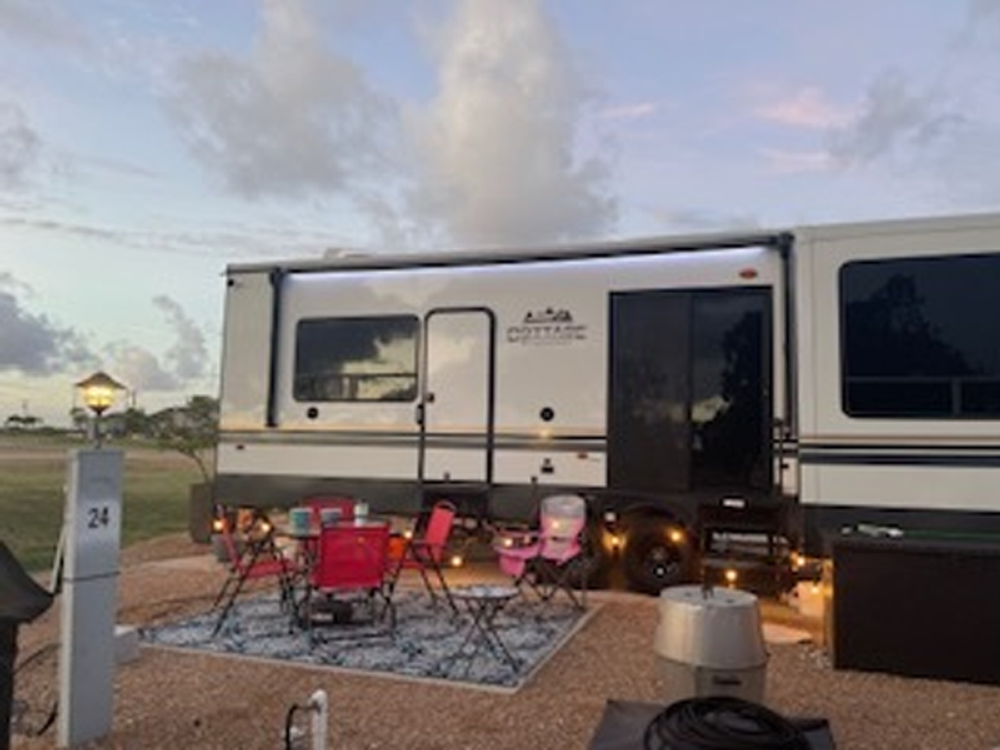 Camper with red chairs outside at Beach Road RV Park