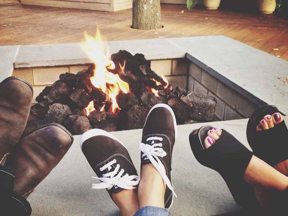 People putting up their feet near the fire pit at JETSTREAM RV RESORT AT THE MED CENTER