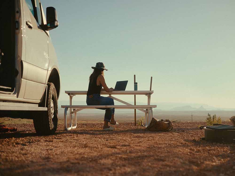 A woman on her laptop outdoors at ROAM AMERICA HORSESHOE BEND