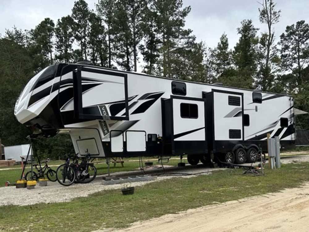 A fifth wheel trailer parked in a gravel site at MIDPOINT I-95 RV PARK