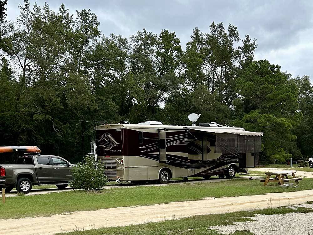 A motorhome and truck in a site at MIDPOINT I-95 RV PARK