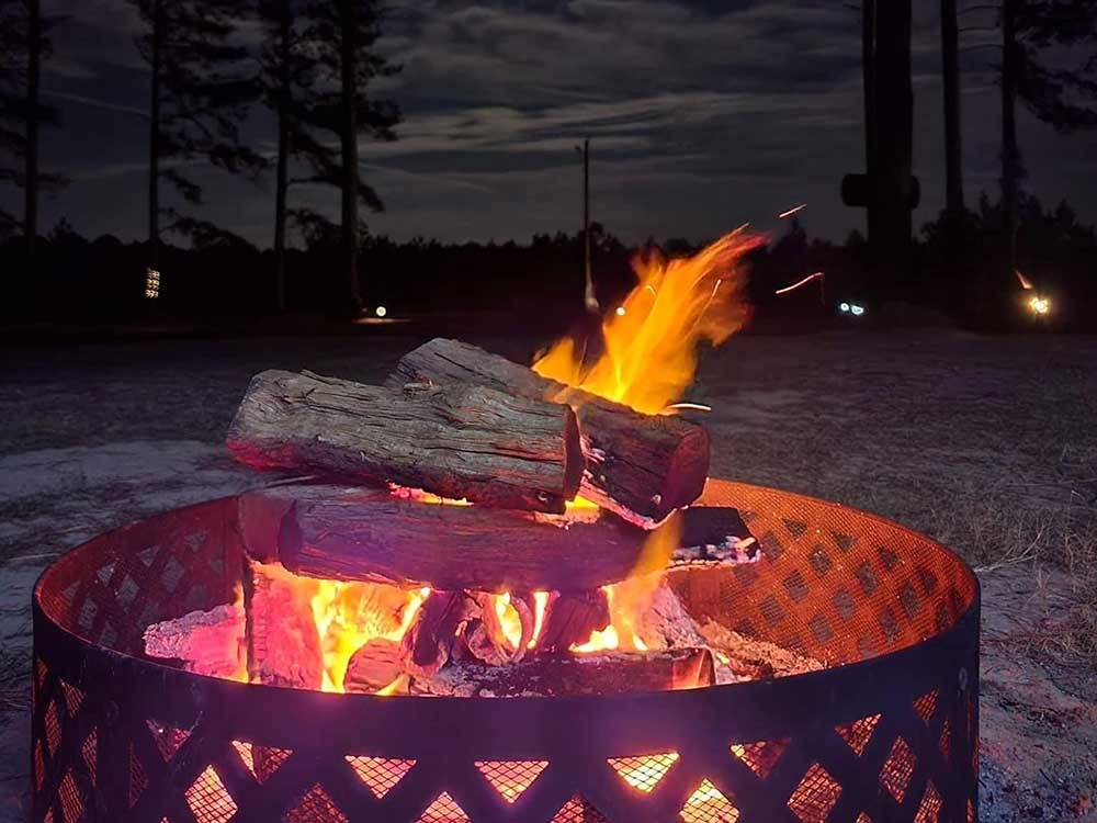 A lit up fire pit at night at DREAM RV PARKS