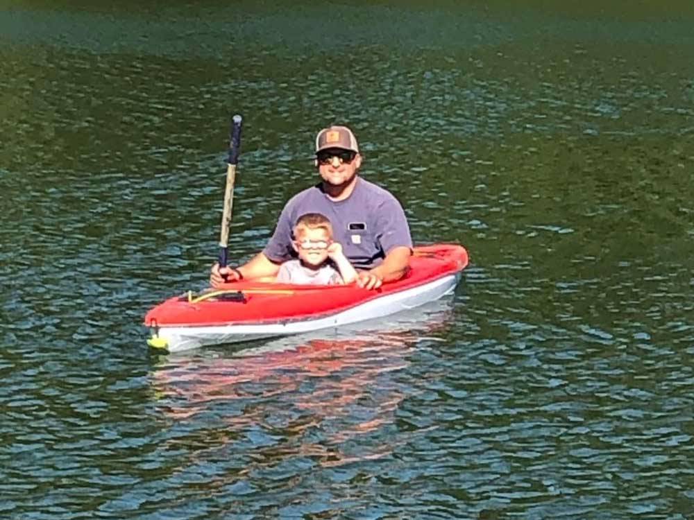 A man and his son in a boat in the water at DREAM RV PARKS