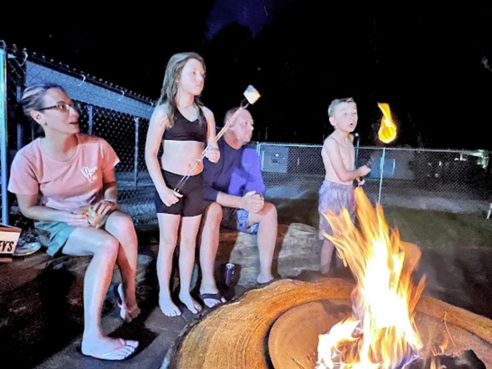 Family roasting marshmallows in the fire pit at VACAY VILLAGE OF PENSACOLA