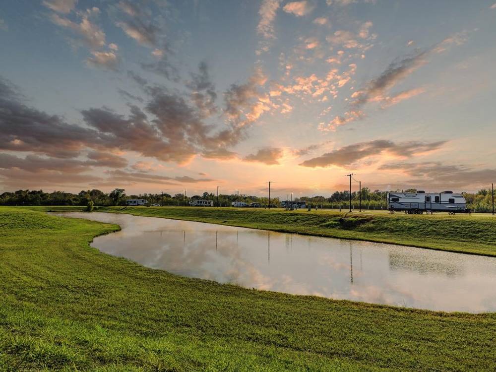 The sun sets over grass park grounds at Medical Center RV Resort