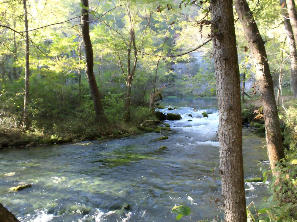 Red barn near a pond at Eminence Cottages and Camp