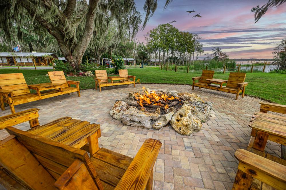 Wooden chairs around a fire ring at Idlewild Lodge & RV Park