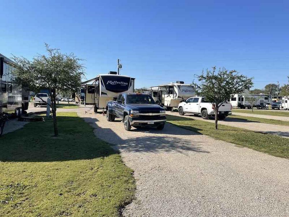 Open grass area next parked trailers Plantation Place RV Park