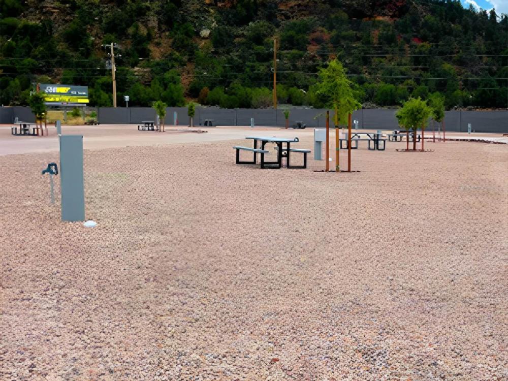 A gravel site with picnic table and tree