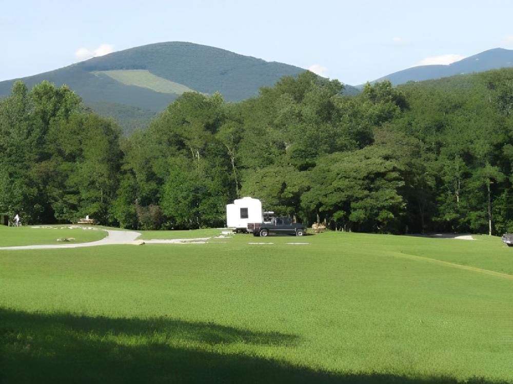 Parked trailer with large grass area at Blue Bear Mountain Camp