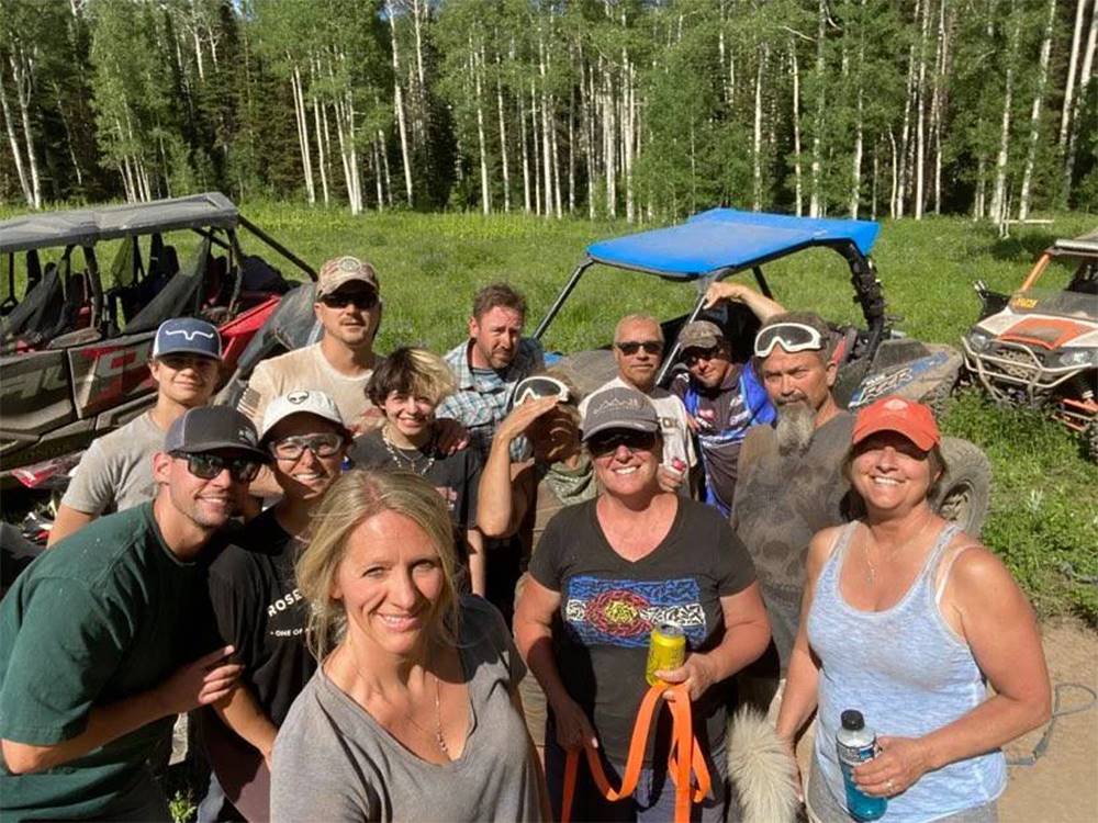 A group of friends smiling for the camera after ATVing in a meadow