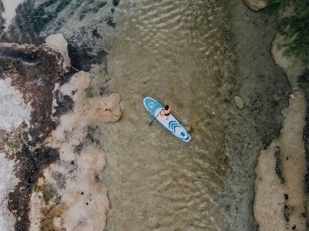 Aerial view of a lady on a paddle board at CAMP COLD SPRINGS