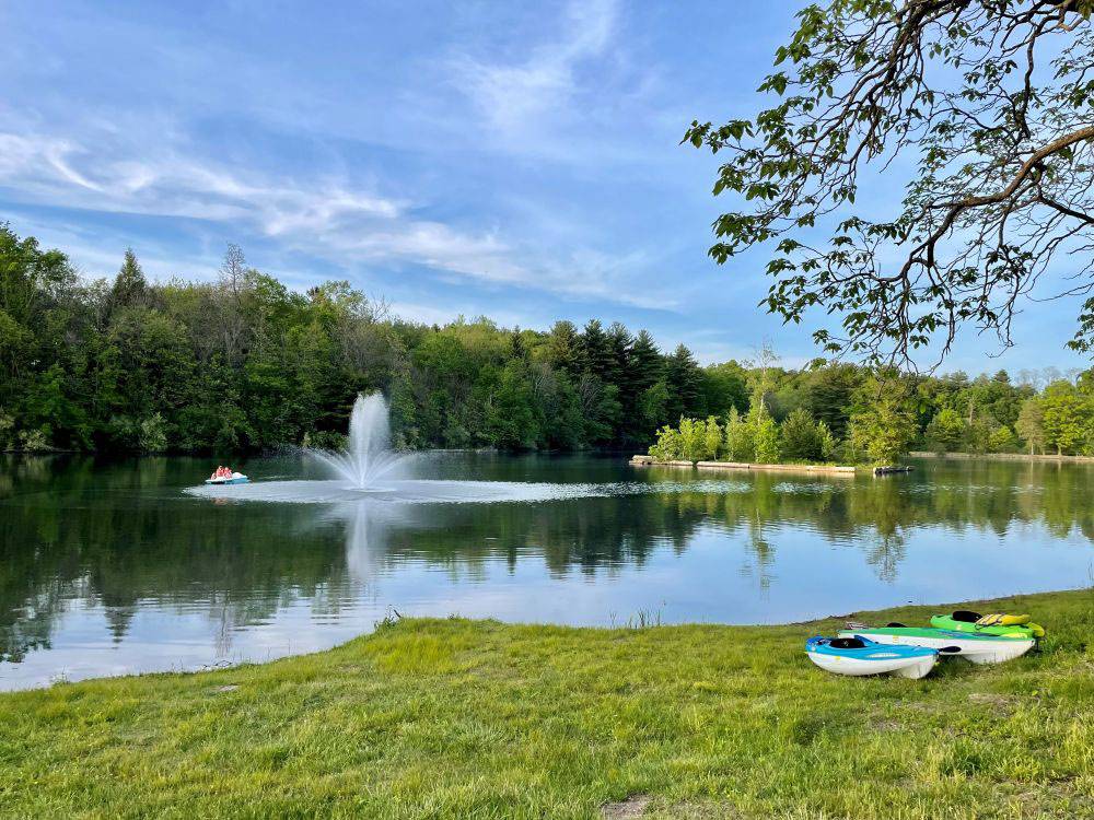 Fountain in the pond and kayaks on the shore